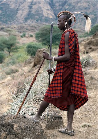 simsearch:862-03820241,k - A Maasai warrior with his hair styled in a most unusual way. His long braids have been wrapped tightly in leather,decorated with beads and tied in an arch over his head. A colobus monkey tail sets this singular hairstyle apart from the more traditional warrior styles. Stock Photo - Rights-Managed, Code: 862-03355139