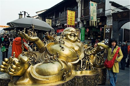 China,Zhejiang Province,Hangzhou. A golden statue of a reclining laughing buddha covered in small buddhas in Qinghefang Old Street in Wushan district. Stock Photo - Rights-Managed, Code: 862-03351633