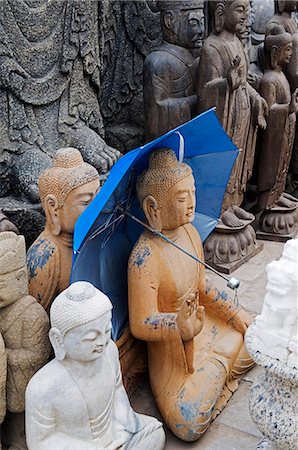 China,Beijing,Panjiayuan Antiques Market. Buddha statue holding an umbrella Stock Photo - Rights-Managed, Code: 862-03351795