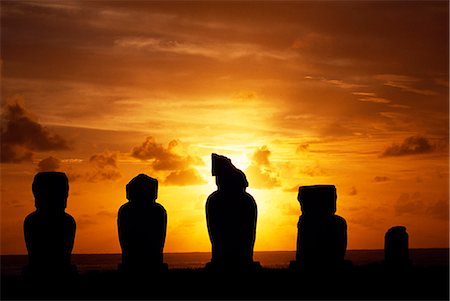 simsearch:862-03360742,k - The sun sets over the Pacific silhouetting Ahu Vai Uri a ceremonial platform with four broad,squat moais and the stump of a fifth,at the ceremonial centre of Tahai. Tahai is just a short walk from Easter Island's main settlement,Hanga Roa on the west coast of the island,backed by the Pacific Ocean. Stock Photo - Rights-Managed, Code: 862-03352099