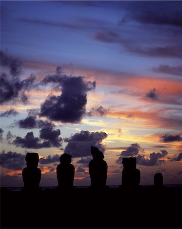 simsearch:862-03360742,k - Silhouetted at sunset on Ahu Vai Uri,four weathered moais and the broked stump of a fifth sit on top of one of the three ahus or platforms of the ceremonial centre of Tahai. Tahai is just a short walk from Hanga Roa,the island's main settlement. Stock Photo - Rights-Managed, Code: 862-03352118