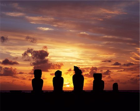 simsearch:862-03360742,k - Silhouetted at sunset on Ahu Vai Uri,four weathered moais and the broked stump of a fifth sit on top of one of the three ahus or platforms of the ceremonial centre of Tahai. Tahai is just a short walk from Hanga Roa,the island's main settlement. Stock Photo - Rights-Managed, Code: 862-03352119