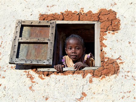 A Malagasy girl looks out of the window of her double-storied Betsileo house. Stock Photo - Rights-Managed, Code: 862-03364024
