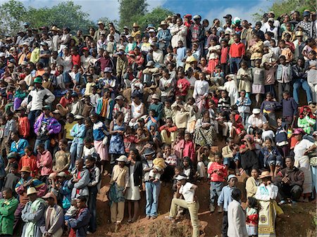 A large crowd of Malagasy people watch a zebu Savika,or rodeo,at the King's Palace,Ambositra. They take place three times a year when young men attempt to ride on the back of a bull. Stock Photo - Rights-Managed, Code: 862-03364047