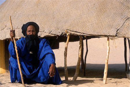 simsearch:862-03437232,k - Crouching blue clad Tuareg elder outside his reed woven shelter Stock Photo - Rights-Managed, Code: 862-03364069