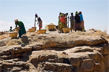 simsearch:400-05910051,k - Mali,Dogon Country,Koundu. The women of the Dogon village of Koundu pound their millet communally on a large flat rock near their village. Stock Photo - Rights-Managed, Code: 862-03364194