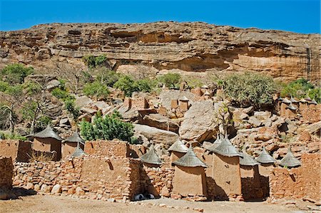 simsearch:400-05910051,k - Mali,Dogon Country,Koundu. The attractive Dogon village of Koundu built among rocks beneath a sandstone cliff of the 120-mile-long Bandiagara escarpment. Dwellings have flat roofs while the numerous granaries to store millet have pitched thatched roofs. Stock Photo - Rights-Managed, Code: 862-03364192
