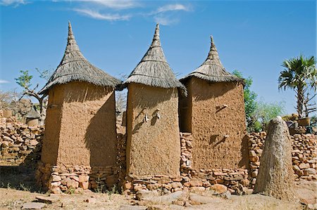 simsearch:400-06099430,k - Mali,Dogon Country,Koundu. A small settlement built among rocks near the Dogon village of Koundu. Dwellings have flat roofs while granaries to store millet have pitched thatched roofs. The Dogon are animists. The sacred earthen mound on the right with an ostrich egg on top is an altar used for sacrifices by the village hogon or priest to appease the ancestors and purify the village. Stock Photo - Rights-Managed, Code: 862-03364193