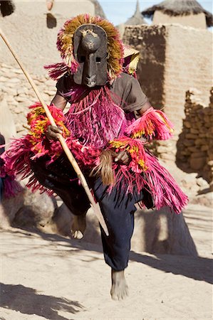 simsearch:400-06076338,k - Mali,Dogon Country,Tereli. A masked dancer leaps high in the air at the Dogon village of Tereli. Tereli is situated among rocks at the base of the spectacular 120-mile-long Bandiagara escarpment. The mask dance is staged at funeral ceremonies to appease the dead and speed them on their way to the ancestral world. Stock Photo - Rights-Managed, Code: 862-03364209