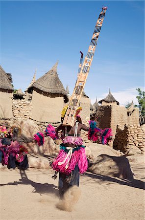 simsearch:400-05910051,k - Mali,Dogon Country,Tereli. A masked dancer wearing the fifteen-foot-high Sirige mask gyrates at the Dogon village of Tereli which is situated among rocks at the base of the spectacular 120-mile-long Bandiagara escarpment. The mask dance is performed at funeral ceremonies to appease the dead and speed them on their way to the ancestral world. Stock Photo - Rights-Managed, Code: 862-03364201
