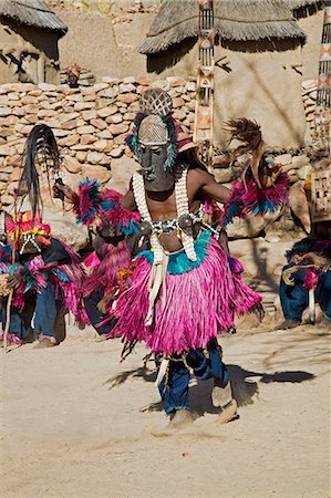 simsearch:400-06076338,k - Mali,Dogon Country,Tereli. A masked dancer wearing coconut shells as breasts performs at the Dogon village of Tereli. Tereli is situated among rocks at the base of the spectacular 120-mile-long Bandiagara escarpment. The mask dance is staged at funeral ceremonies to appease the dead and speed them on their way to the ancestral world. Stock Photo - Rights-Managed, Code: 862-03364210