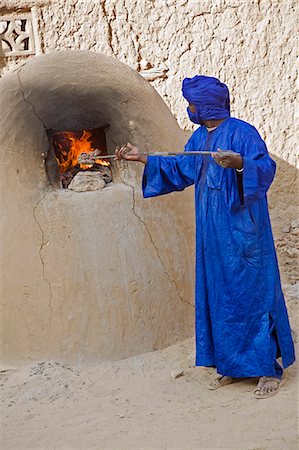 simsearch:862-03437232,k - Mali,Timbuktu. A Tuareg man stokes the fire of a bread oven in Timbuktu. Stock Photo - Rights-Managed, Code: 862-03364245