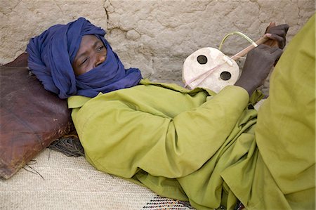 simsearch:862-03437232,k - Mali,Timbuktu. A Tuareg man relaxes while playing his homemade stringed instrument at Timbuktu. Stock Photo - Rights-Managed, Code: 862-03364252