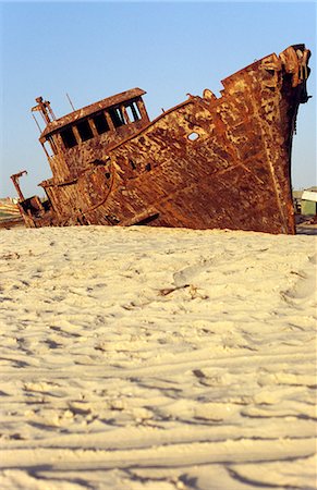 The rusting hulk of a shipwrecked freighter sits buried in the sands of the Plage de Pecheurs (Fishermens Beach) near Nouakchott. The waters off the west African nation are amongst the richest fishing grounds in the world. Stock Photo - Rights-Managed, Code: 862-03364312