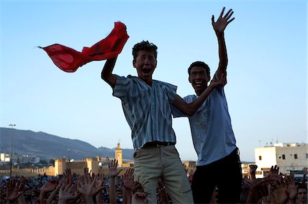 Morocco,Fes. Two proud Moroccan boys wave their national flag above the crowds at a concert in the Place Boujloud,during the Fes Festival of World Sacred Music. Stock Photo - Rights-Managed, Code: 862-03364809