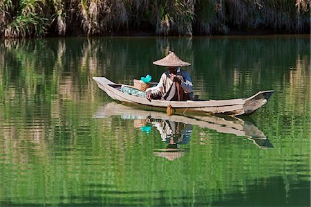 Myanmar,Burma,Lay Mro River. A Rakhine man fishes from a small wooden boat in the still waters of the Lay Myo River. Stock Photo - Rights-Managed, Code: 862-03365310