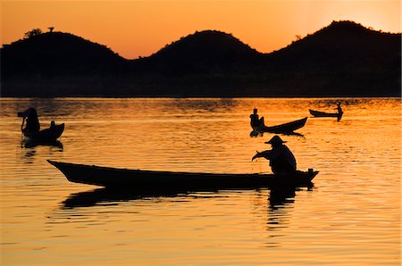 Fishermen bathed in the golden hues of the setting sun as they fish from their little boats on the Lay Myo River. Stock Photo - Rights-Managed, Code: 862-03365320