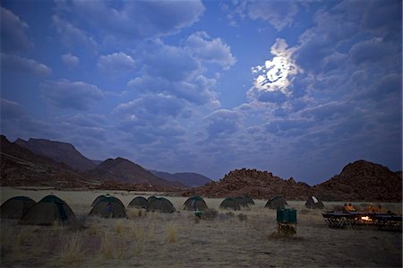 Namibia,Damaraland,Brandberg. The moon rises through a dramatic cloud filled sky over a safari camp set on the flanks of the Brandberg Mountain,Namibia's highest peak. Stock Photo - Rights-Managed, Code: 862-03365385