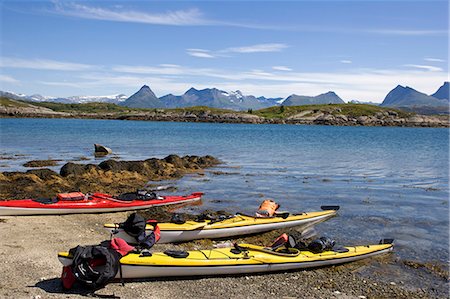 Norway,Nordland,Helgeland. Sea kayaking down the coast of Norway in the summer - a group of kayaks pulled up on the beach with a range of mountains in the background Stock Photo - Rights-Managed, Code: 862-03365668