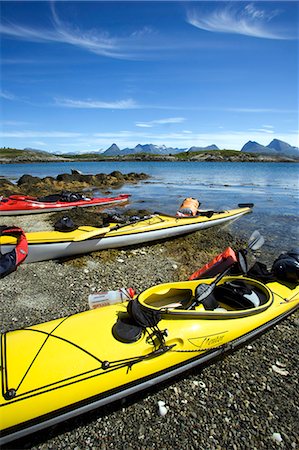 Norway,Nordland,Helgeland. Sea kayaking down the coast of Norway in the summer - a group of kayaks pulled up on the beach with a range of mountains in the background Stock Photo - Rights-Managed, Code: 862-03365669