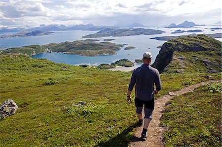 people hiking on trail - Norway,Nordland,Helgeland,Rødøy Island. The island of Rødøy is dominated by the 400 metre high peak of Rødøyløva,which translated means 'Lion of Rødøy' and which from a distance also looks like a sphinx after climbing a steep but easy path the view from the top affords superb views of the surrounding islands. Stock Photo - Rights-Managed, Code: 862-03365717