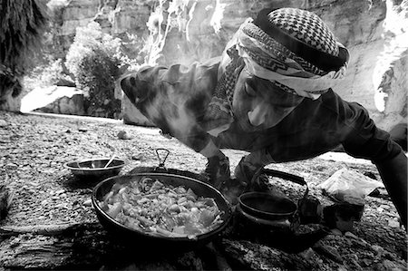 Jordan,Petra Region. Stopping for lunch in the Wadi Daphna,over an open fire a local Bedu guide prepares traditional Jordanian tea and cooks up fresh vegetables Stock Photo - Rights-Managed, Code: 862-03365896