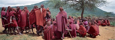 A large gathering of Maasai warriors,resplendent with long Ochred braids,listen to instructions from their chiefs and elders during a ceremony Stock Photo - Rights-Managed, Code: 862-03366318