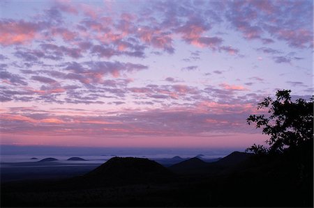 simsearch:862-03355195,k - At daybreak,cone-shaped hills accentuated by ground mist dot the foothills of the 7,000-foot-high Chyulu Hills. This beautiful range is of relatively young volcanic origin. Stock Photo - Rights-Managed, Code: 862-03366397