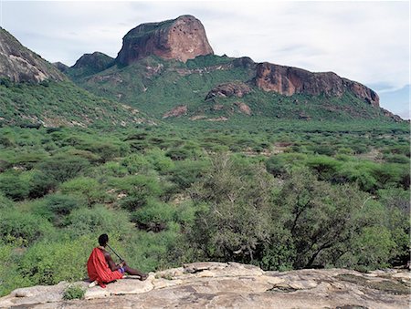 simsearch:862-03355162,k - A Samburu warrior plays a homemade flute overlooking Poi,a prominent rock feature in the Ndoto Mountains of Samburuland.The Samburu of Northern Kenya are a semi-nomadic pastoral community related to their more famous cousins,the maa speaking Maasai. Foto de stock - Con derechos protegidos, Código: 862-03366415