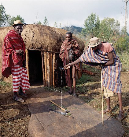 The day before Samburu boys are circumcised in their lorora,(a purpose-built circumcision encampment),senior elders will bless the sharp instruments of every household,such as pangas and axes,by pouring a little milk over them as they intone a blessing. The instruments must be laid out on the oxhide upon which the boy of each household will be circumcised. Stock Photo - Rights-Managed, Code: 862-03366541