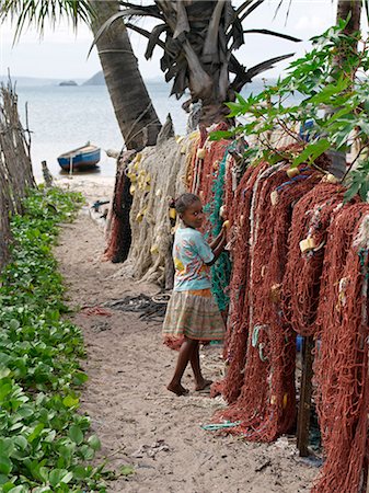 A young Malagasy girl among fishing nets at Ramena,a fishing village a short distance from Antsiranana,more commonly known as Diego. Diego's deep-water harbour encircled by hills is of strategic importance to Madagascar. Stock Photo - Rights-Managed, Code: 862-03367259