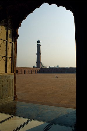 pakistan - Completed in 1676 AD by the Mughal emperor Aurangzeb,Badshahi Mosque can accommodate 60,000 worshippers in its courtyard. Four minarets sour above the mosque's corners. Stock Photo - Rights-Managed, Code: 862-03360407