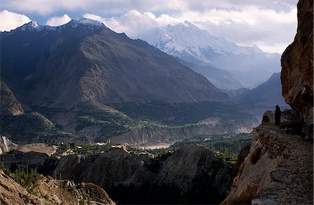 pakistan - A Burusho man strolls along one of several gotsil,or irrigation channels,hewn into the side of a cliff,that flow out of Ultar Nala. Irrigation is vital for Hunza's crops and orchards. Stock Photo - Rights-Managed, Code: 862-03360402