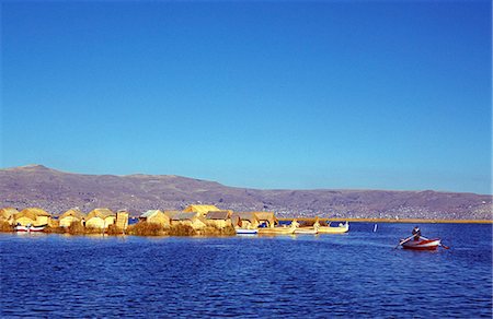 simsearch:862-03360742,k - An Indian man rows his boat away from one of the Uros or floating red islands across Lake Titicaca Stock Photo - Rights-Managed, Code: 862-03360447