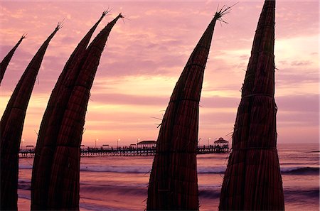 simsearch:862-03360742,k - Totora (reed) boats stacked upright on the beach at Huanchaco,in northern Peru,are silhouetted by the dusk light. Caballitos de totora (little horses of reeds) are the traditional fishing boats of the local fishermen. Stock Photo - Rights-Managed, Code: 862-03360495
