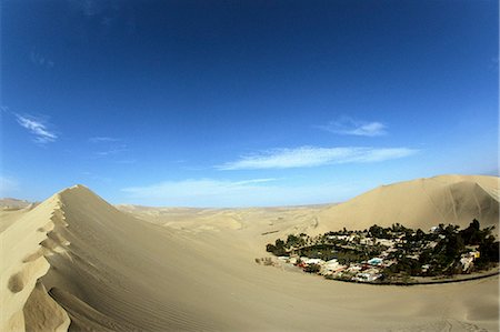 The oasis village of Huacachina sits amidst the giant sand dunes of Peru's southern coastal desert Stock Photo - Rights-Managed, Code: 862-03360536