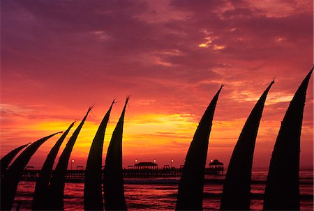 simsearch:862-07495921,k - The setting sun paints the sky red,silhouetting totora (reed) boats stacked on the beachfront at Huanchaco,in northern Peru. The boats are the traditional craft of the local pescadores (fishermen). Foto de stock - Con derechos protegidos, Código: 862-03360562