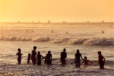 simsearch:862-03360742,k - Kids play in the surf,while surfers and fishing boats sit offshore at Mancora,northern Peru. Stock Photo - Rights-Managed, Code: 862-03360570