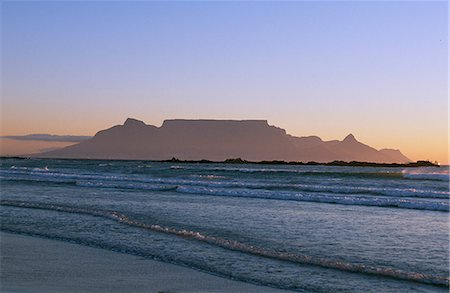simsearch:862-03355195,k - Surf rolls onto a deserted beach near Bloubergstrand with Cape Town and Table Mountain behind Stock Photo - Rights-Managed, Code: 862-03361186