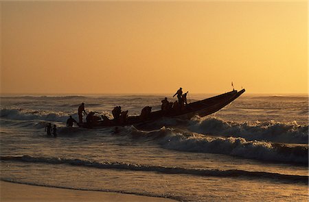 Fishermen launch their boat into the Atlantic Ocean at sunset Stock Photo - Rights-Managed, Code: 862-03361575