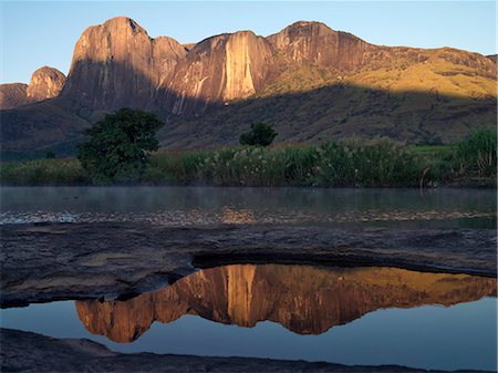 Massif de Tsaranoro reflected in a rock pool in the early morning. The spectacular granite peaks and domes of the Andringitra Mountains have become a popular hiking destination. Stock Photo - Rights-Managed, Code: 862-03363993