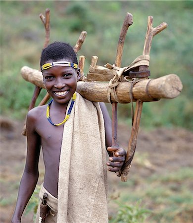 ethiopia boy - A Konso youth of southwest Ethiopia carries home a wooden yoke used by pairs of oxen to plough the land. Stock Photo - Rights-Managed, Code: 862-03437076