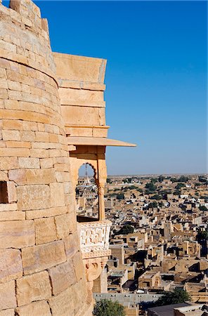 simsearch:400-05146135,k - India,Rajasthan,Jaisalmer. Jaisalmer Fort - balcony and tower of the main 'living' fort built in 1156 by the Bhati Rajput ruler Jaisal. It is situated on Trikuta Hill and has been the site of many battles,overlooking the main modern city spread out below it defenses. Stock Photo - Rights-Managed, Code: 862-03437118