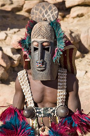 simsearch:400-06099430,k - Mali,Dogon Country,Tereli. A masked dancer wearing coconut shell breasts performs at the Dogon village of Tereli. Tereli is situated among rocks at the base of the spectacular 120-mile-long Bandiagara escarpment. The mask dance is staged at funeral ceremonies to appease the dead and speed them on their way to the ancestral world. Stock Photo - Rights-Managed, Code: 862-03437228