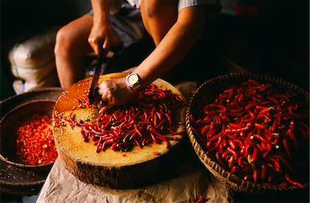 Shop owner chopping red chili peppers in CholonCholon was first settled by ethnic Chinese or Hoa and now has over million population and one of the biggest sprawl of markets,Temples and Pagodas in Ho Chi Minh City. Stock Photo - Rights-Managed, Code: 862-03437706