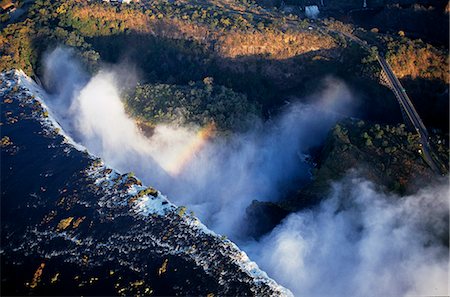 Aerial view of the Zambezi River as it plummets over the Victoria Falls,which spans the border between Zambia and Zimbabwe. The Victoria Falls is 1800 metres wide and 110 metres deep. It is one of the Seven Natural Wonders of the World Stock Photo - Rights-Managed, Code: 862-03438012