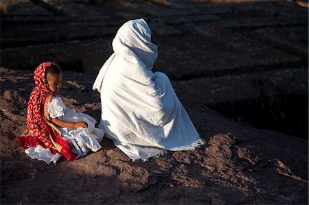 simsearch:862-03353978,k - Ethiopia, Lalibela. A woman prays by Bet Giyorgis, whilst her daughter loses concentration. Stock Photo - Rights-Managed, Code: 862-03711142