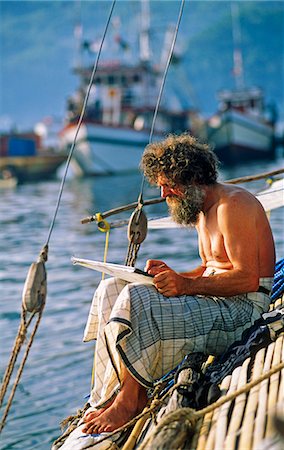 Indonesia,Sulawesi,Bitung. Norwegian artist sketching on a tradition Indonesian Dhow in the harbour of Bitung. Stock Photo - Rights-Managed, Code: 862-03711826