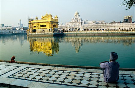 simsearch:862-03711843,k - A Sikh pilgrim pauses for reflection by Amrit Sarovar,the Pool of Immortality-Giving Nectar,and the Golden Temple. Stock Photo - Rights-Managed, Code: 862-03711896