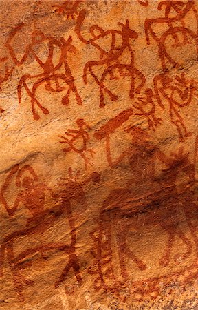 Hidden away in rocky overhangs in a ten kilometer stretch of hillside,this prehistoric rock art is the most impressive in India. These hunting scenes are believed to date from around 8000-5000 BC. Stock Photo - Rights-Managed, Code: 862-03711901